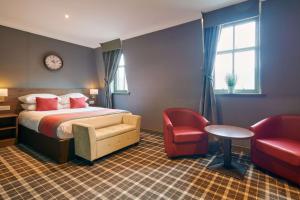 グラスゴーにあるBest Western Glasgow Hotelのベッドと椅子付きのホテルルーム