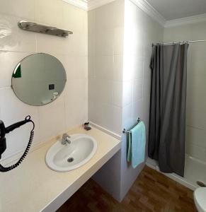 uma casa de banho com um lavatório, um espelho e um chuveiro em Apartamentos Halley em Puerto Rico de Gran Canaria
