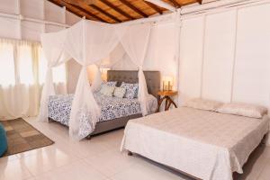 a bedroom with two beds and a mosquito net at Paraíso Natural Ecohotel in San Bernardo del Viento