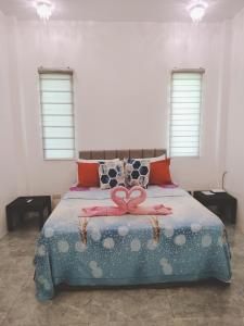 a bedroom with a bed with a pink bow on it at Bais City Home Staycation in Bais