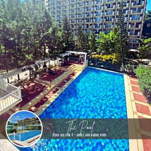 een groot zwembad met een groot gebouw op de achtergrond bij Vittoria Suites at Northpoint Pines Estate in Davao City