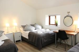 een slaapkamer met een bed, een bureau en een spiegel bij Miðhraun - Lava resort in Midhraun