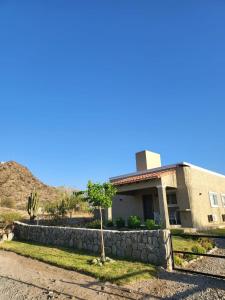 un edificio con una pared de piedra junto a una casa en CASAS Viñedos de Cafayate Alquiler Temporario en Cafayate