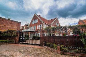 a brick house with a wrought iron fence at Apartasuites Plaza Antigua Bogota in Bogotá