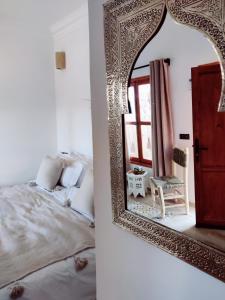 - une chambre avec un lit et un miroir dans l'établissement Zagora Oasis Lodge, à Zagora