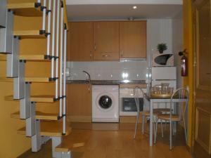cocina con lavadora, mesa y sillas en Apartamentos Zaragoza Centro, en Zaragoza