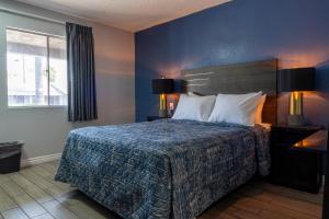 una camera con un letto con una parete blu di Pala Motel a Pomona