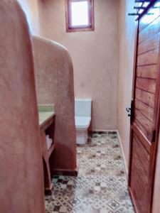 La salle de bains est pourvue de toilettes, d'un lavabo et d'une porte. dans l'établissement Zagora Oasis Lodge, à Zagora