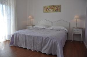 a bedroom with a bed with a white bedspread and two night stands at Le stanze di Rebecca in Tor Vergata