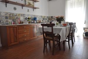uma cozinha com uma mesa e cadeiras numa cozinha em Le stanze di Rebecca em Tor Vergata