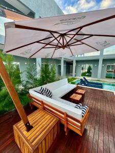 een patio met een witte bank en een parasol bij Apartamento localizado em condomínio fechad0 em Barra Grande - PI in Parnaíba