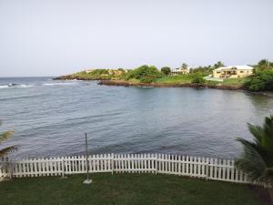 a view of the ocean from a house with a white fence at SeaLaVie Apartments - Grenada in Saint Georgeʼs