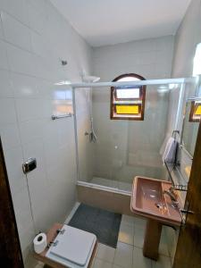 a bathroom with a sink and a shower at Casa Central Hospedagem in Miguel Pereira