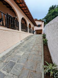 a stone walkway in front of a building at Casa Central Hospedagem in Miguel Pereira +21 photos