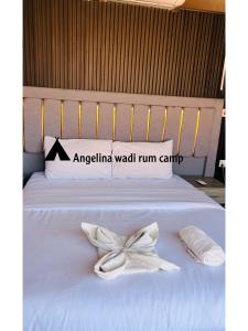 a bed with two white towels and a bow on it at Angelina Wadi Rum camp in Wadi Rum
