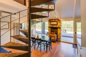a dining room with a table and a spiral staircase at Updated Three Rivers Vacation Rental with Gas Grill in Three Rivers
