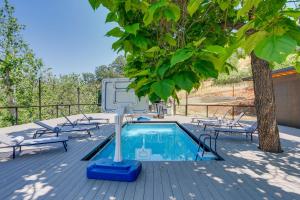 a swimming pool with chairs and a tree on a deck at Updated Three Rivers Vacation Rental with Gas Grill in Three Rivers