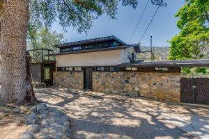 a house with a stone wall and a tree at Updated Three Rivers Vacation Rental with Gas Grill in Three Rivers
