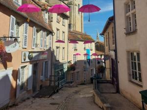 een groep roze paraplu's boven een straat bij Gite Le Lattier in Lussac-les-Églises