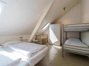 Het Grootenhuis في Olst: غرفة نوم مع سريرين بطابقين في العلية
