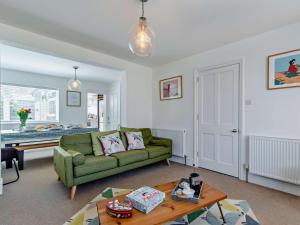a living room with a green couch and a table at 3 Bed in Mundesley 75160 in Mundesley