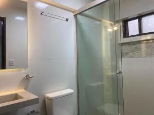 a bathroom with a glass shower and a toilet at Amaca Hostal in Santa Cruz de la Sierra