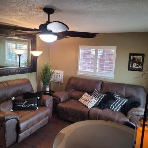 uma sala de estar com dois sofás de couro castanho em Mountain View Lodging Cody em Cody