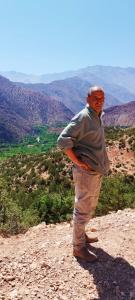 Ein Mann steht auf einem Berg in der Unterkunft Dar Imoughlad in Marrakesch