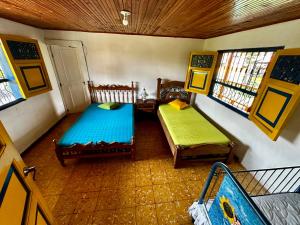 um quarto com duas camas e duas janelas em Finca La Española Quimbaya Quindio em Quimbaya