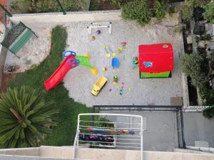 uma vista aérea de um parque infantil com brinquedos e uma mesa em Apartments with a parking space Postira, Brac - 2911 em Postira