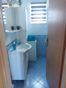 uma casa de banho branca com um lavatório e um chuveiro em Apartments with a parking space Postira, Brac - 2911 em Postira