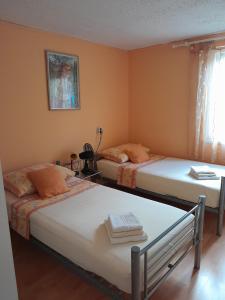 2 camas individuales en una habitación con paredes de color naranja en Apartments with a parking space Postira, Brac - 2911 en Postire
