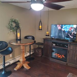 uma sala de estar com uma televisão, uma mesa e uma lareira em Mountain View Lodging Cody em Cody