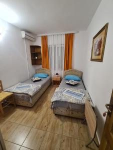 a bedroom with two beds and a table and chairs at Sobe Nedović in Budva