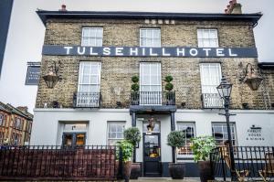 Tulse Hill Hotel في لندن: فندق في لندن مع لافتة مكتوب عليها فندق قاعة القرية