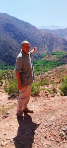 a man standing on the side of a mountain at Dar Imoughlad in Marrakech