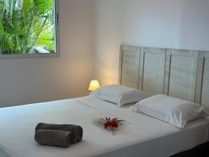 una camera da letto con un letto bianco e un fiore sopra di Sur La Mer - Appartement Deux chambres à Schoelcher a Schœlcher