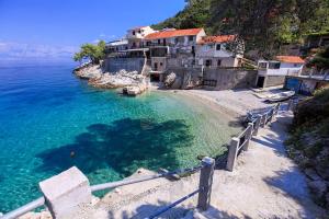 a beach with a group of houses and the water at Seaside secluded apartments Cove Pobij, Hvar - 8702 in Gdinj