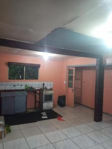 cocina con paredes rosas y suelo de baldosa blanca en Kapeta Cabin en Hofoa