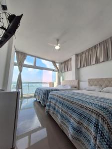 グアルジャにあるSuítes Pitangueirasの海の景色を望むベッドルーム1室(ベッド2台付)
