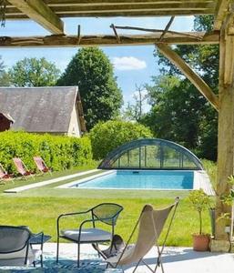 Les Montils的住宿－La Moyendrie，一个带椅子的庭院和一个游泳池