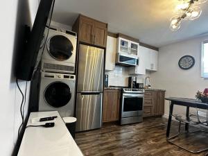 a kitchen with stainless steel appliances and a table at Refuge urbain à Beauport in Quebec City