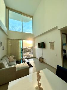 a living room with a couch and a table at Apartamento Duplex con vista al mar in Gaira