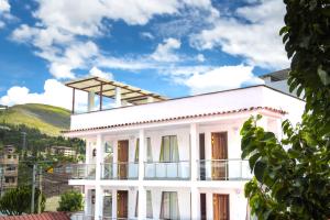 a white building with a balcony in front of a mountain at La Chacana Hotel Boutique in Huaraz +20 photos