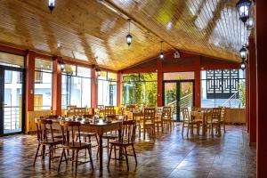 a dining room with tables and chairs and windows at La Chacana Hotel Boutique in Huaraz