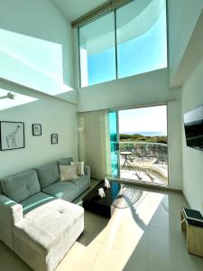a living room with a couch and a large window at Apartamento Duplex con vista al mar in Gaira