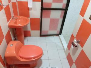 uma casa de banho com um WC vermelho e um lavatório. em Hostal Beds of salt Ga em Uyuni