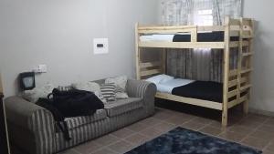 a living room with a couch and bunk beds at Secunda BackPackers in Secunda