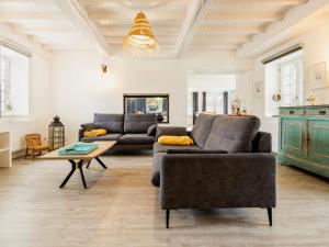 a living room with two couches and a table at Maison de charme avec jardin près de Nantes, 4 chambres, wifi, équipements bébé et babyfoot - FR-1-306-1272 in Le Bignon