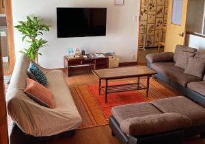 出雲市にある出雲古民家の宿maemoriのソファとテーブルのあるリビングルーム